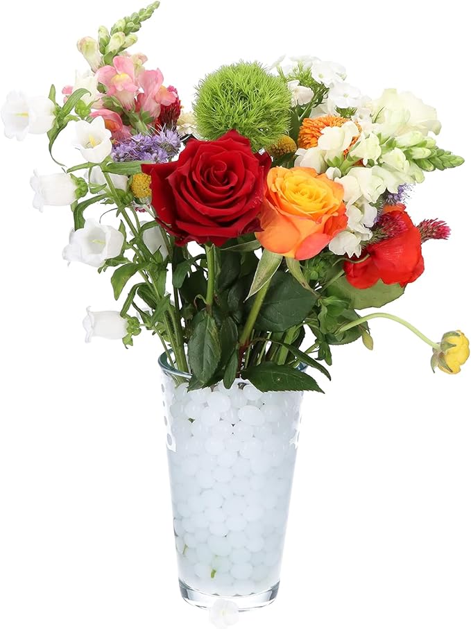 Composizione floreale colorata in un vaso con perle d'acqua bianche, decorazione stagionale
