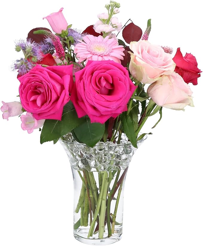 Bouquet di rose rosa in un vaso di vetro con perle d'acqua trasparenti che sorreggono i fiori